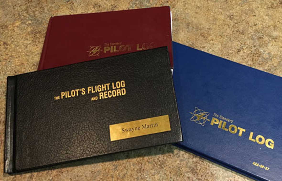 Pilot logbooks stacked on a table