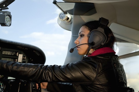 Pilot at the controls wearing a headset